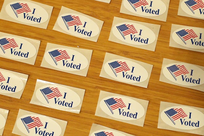 I Voted stickers are spread out on a table next to the ballot drop box for in-person voting in Bremerton.