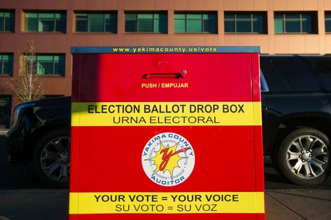 People line up to drop their primary election ballots at the drop box across the street from the Yakima County Courthouse, Tuesday, Aug. 2, 2022, in Yakima, Wash.