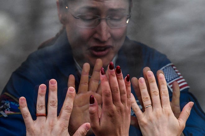 NASA astronaut Christina Hammock Koch, a member of the International Space Station expedition 59/60, gestures from inside a bus during a farewell ceremony outside the Cosmonaut hotel prior to the launch onboard the Soyuz MS-12 spacecraft from the Russian-leased Baikonur cosmodrome in Kazakhstan on March 14, 2019.