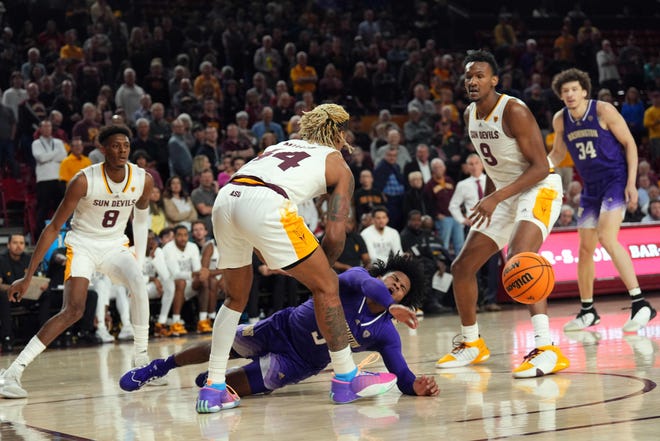 Washington Huskies guard Sahvir Wheeler (5) passes the ball by Arizona State Sun Devils guard Adam Miller (44) as he falls to the court during the first half at Desert Financial Arena.