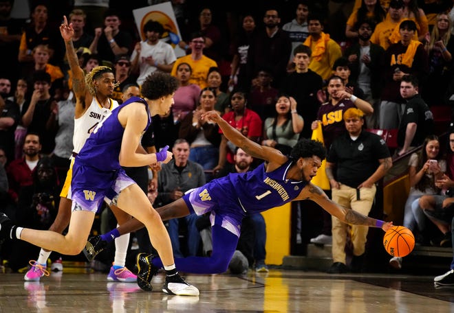 Washington Keion Brooks Jr (1) dives for a loose ball falling into the fans on the sideline against ASU during a game at Desert Financial Arena.