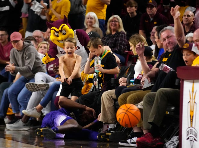 Washington Keion Brooks Jr (1) dives for a loose ball falling into the fans on the sideline against ASU during a game at Desert Financial Arena.