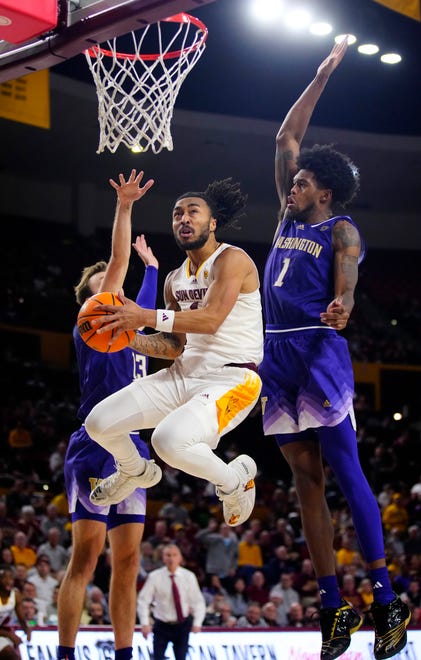 ASU guard Frankie Collins (1) makes an acrobatic layup against Washington Keion Brooks Jr. (1) during a game at Desert Financial Arena.