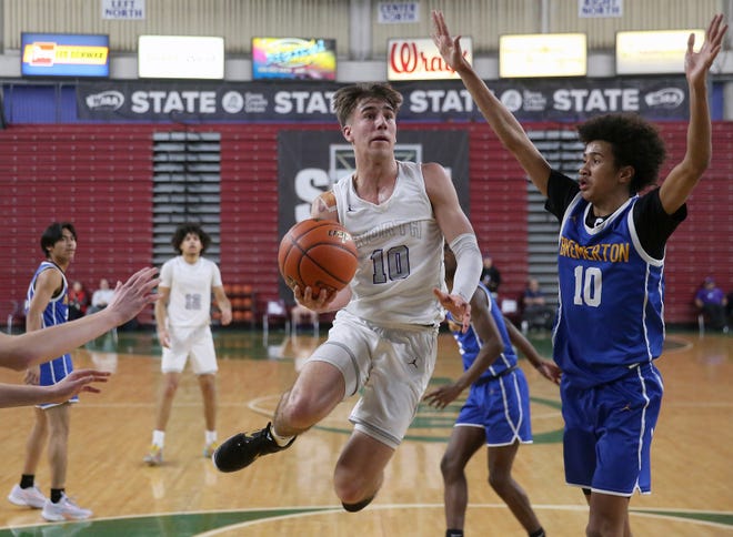 North Kitsap’s Cade Orness goes up for a shot while being guarded by Bremerton’s Jalen Davis, right, during their 2A state championship game at the Yakima SunDome on Saturday, March 2, 2024. North Kitsap won the game gets a 71-48 and took home the third place trophy while Bremerton brought home fifth place.