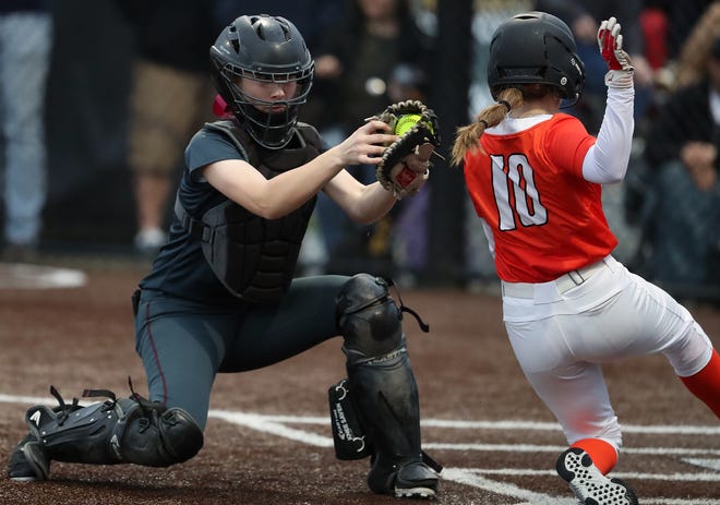 Central Kitsap’s Alex Berg (10) slides into home ahead of the tag of Kingston catcher Brooke Steele during their game in Silverdale on Friday, March 22, 2024.