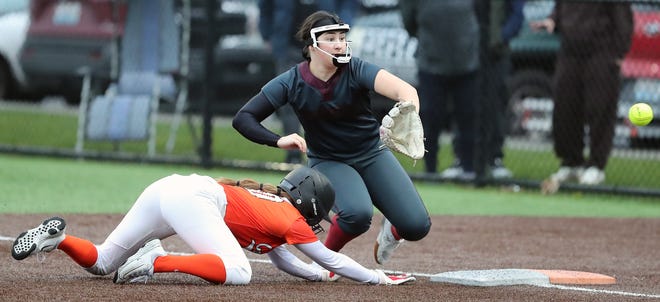 Central Kitsap’s Central Kitsap’s Alex Berg dives back to first ahead of the throw to Kingston’s Audrey Rienstra in Silverdale on Friday, March 22, 2024.